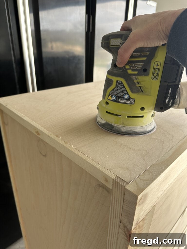 Craft Your Own Custom Dresser 29 Sanding the dresser surface with an orbital sander