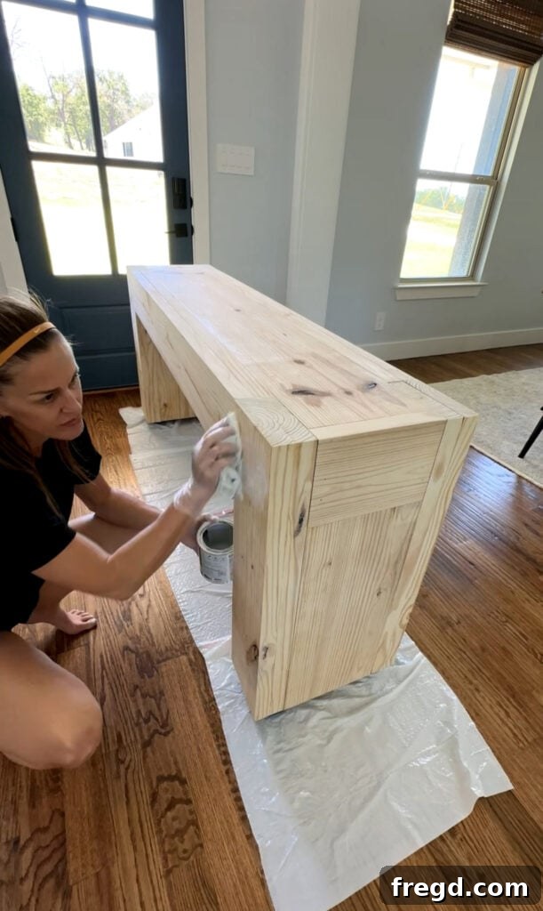 Applying Behr White Wash Pickling stain to the console table