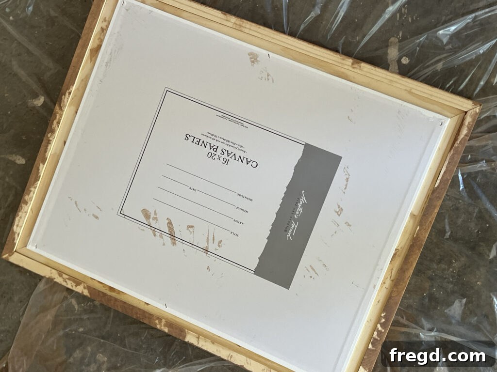 Close-up of a canvas panel being secured to the inner frame using a staple gun and half-inch staples.