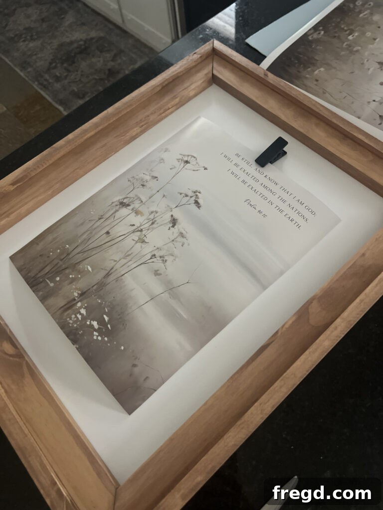 An assembled frame with a decorative drawer pull at the top and a clip attached to the canvas, ready for artwork.