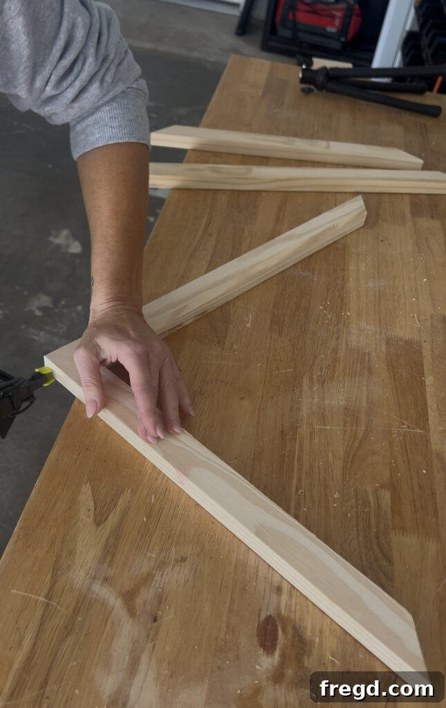 Close-up of pine boards being cut with a miter saw for the inner frame.