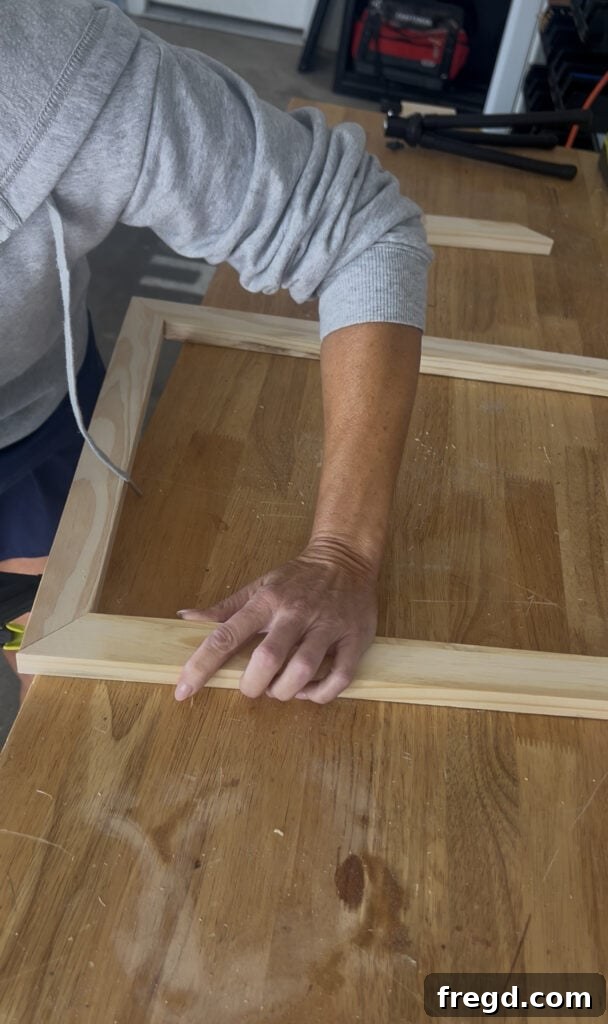 Two pieces of pine board joined at a 45-degree mitered corner with wood glue, forming part of the inner frame.