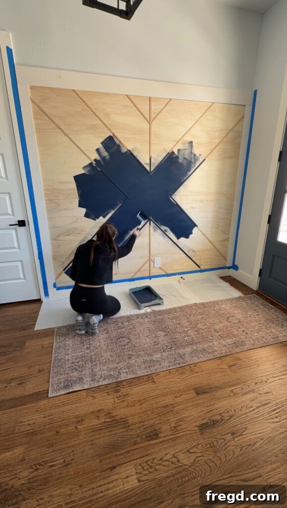 Removable Modern Accent Wall DIY for Renters 15 Painting the geometric accent wall in a deep navy color, Sherwin Williams Naval.