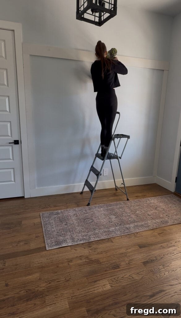 Removable Modern Accent Wall DIY for Renters 5 Measuring and attaching the top MDF trim piece to complete the accent wall frame.