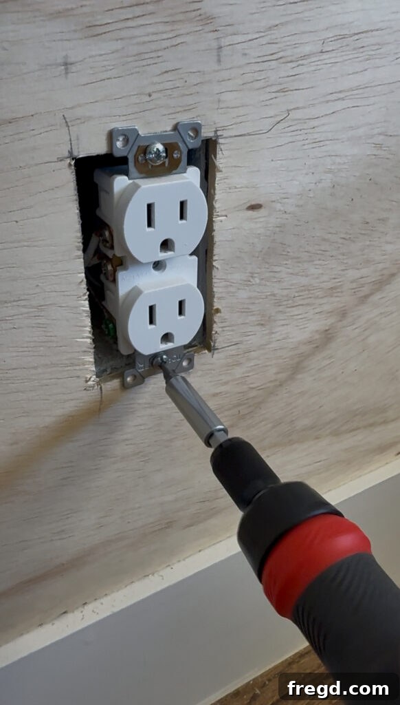Removable Modern Accent Wall DIY for Renters 8 Sliding the plywood panel with the outlet cutout behind the electrical box.