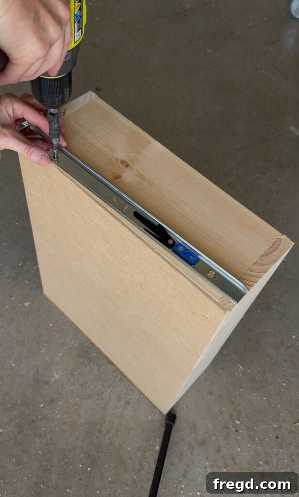 Easy Wood Nightstand Builds for Newbies 14 Inside part of the drawer slide being attached to the side of the drawer box, using the plywood bottom as a placement guide.