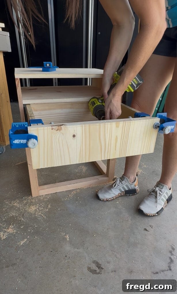 Easy Wood Nightstand Builds for Newbies 15 Drawer front being aligned and attached to the drawer box, demonstrating the use of a Kreg Drawer Front Mounting Jig.