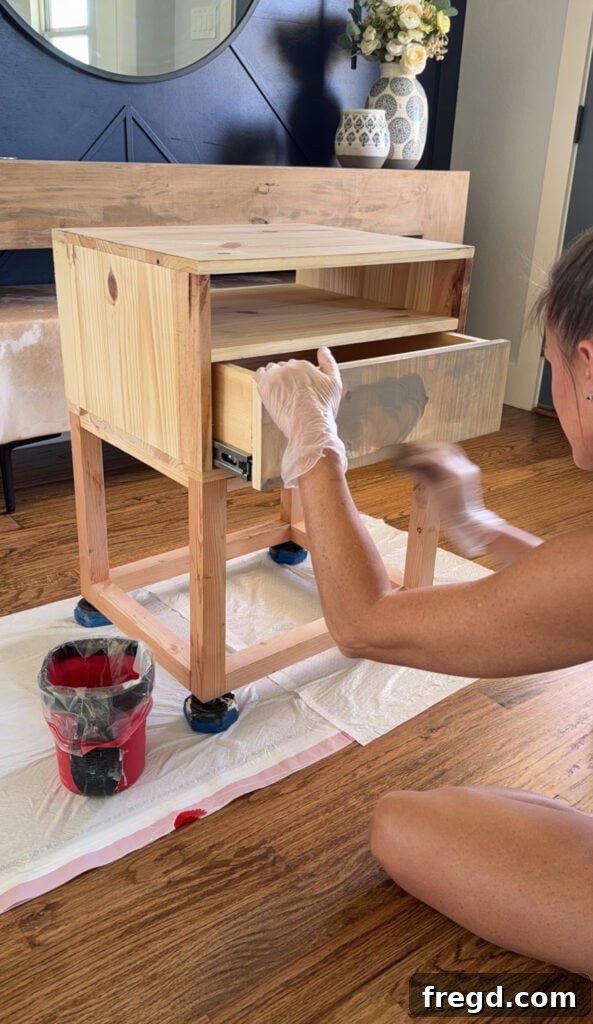 Easy Wood Nightstand Builds for Newbies 20 Applying an even coat of custom mixed wood stain to the nightstand.