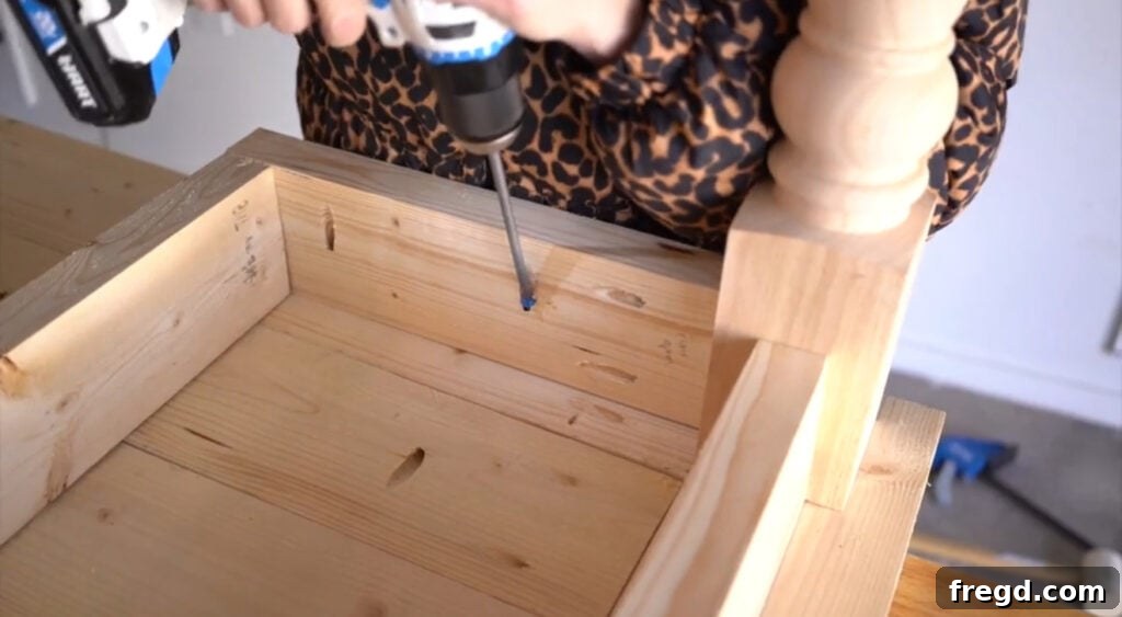 Attaching the desk base to the upside-down tabletop