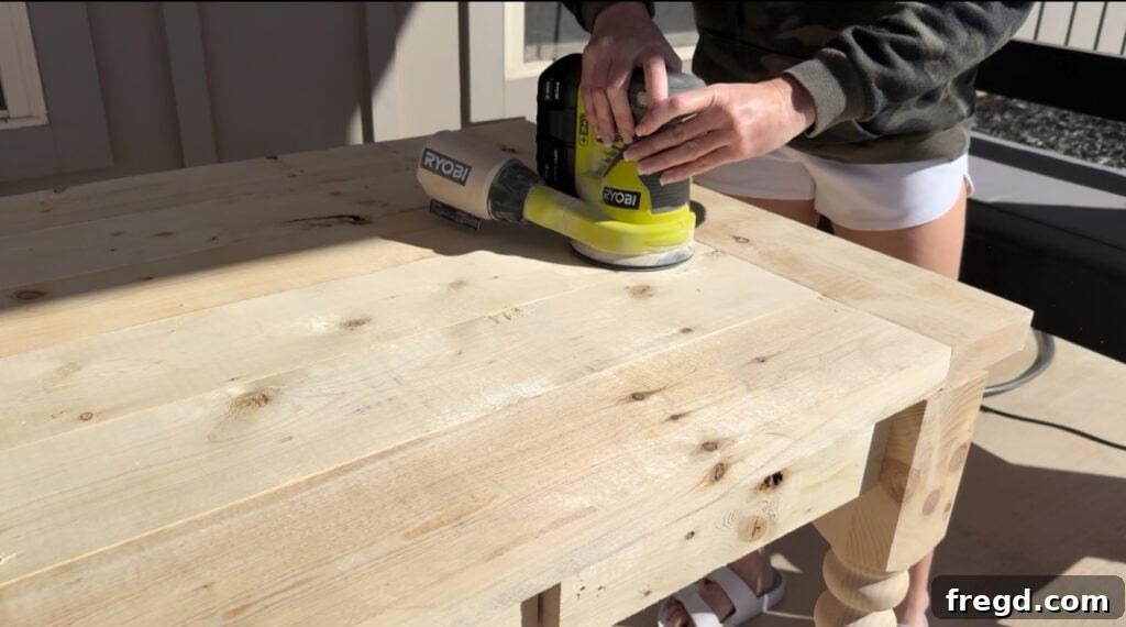 Sanding the completed DIY farmhouse desk
