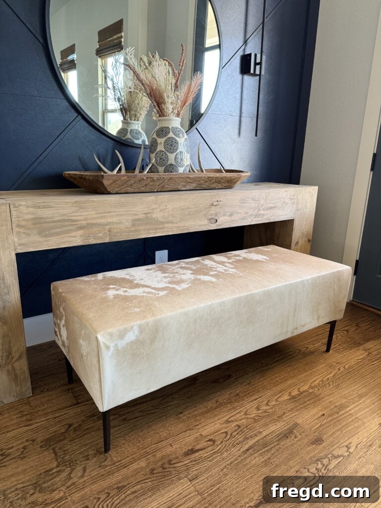 Modern rustic cowhide upholstered bench built with 2x4s and free plans, showcasing its elegant design and sturdy construction.
