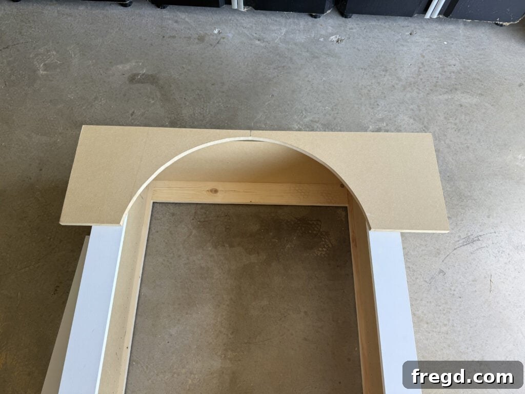 Positioning the arched piece on top of the side face frame pieces to mark for trimming.