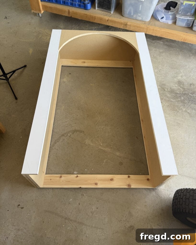 Attaching the completed arched face frame to the hutch using brad nails and wood glue.