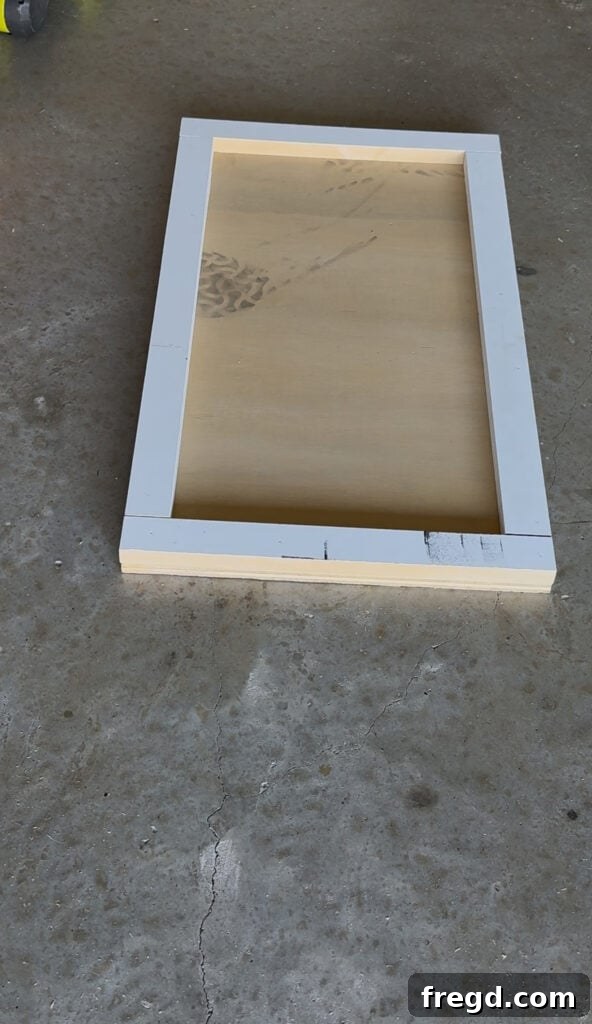 Assembling a cabinet door by attaching trim pieces to the main panel.