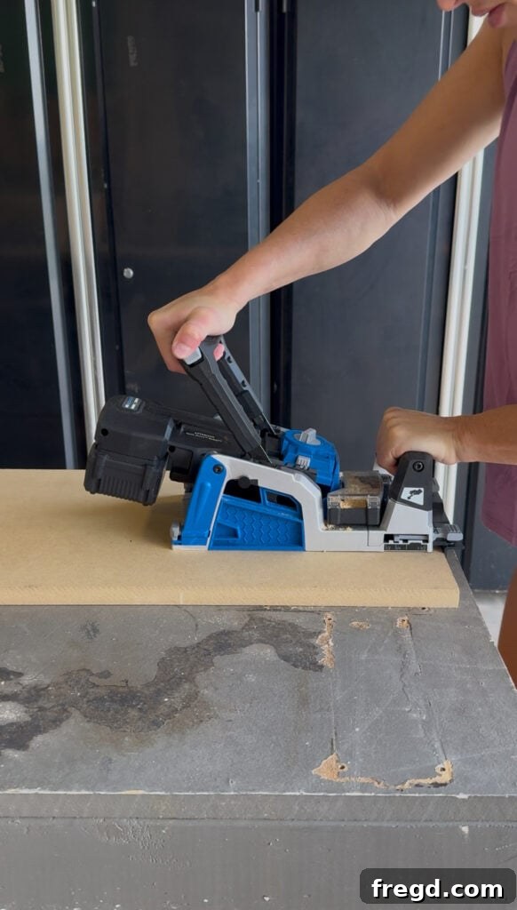 Drilling pocket holes along the edges of an MDF panel.