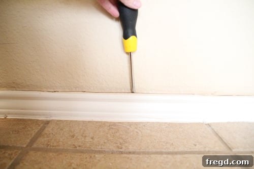 Baseboard Removal with Utility Knife Removing the old baseboard with a utility knife