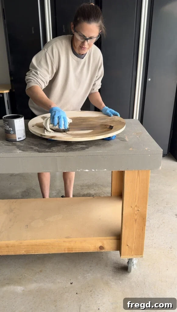 Applying stain to the sanded wood circle.