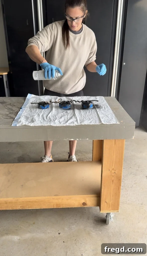 Spray painting the 'Welcome' lettering in black.