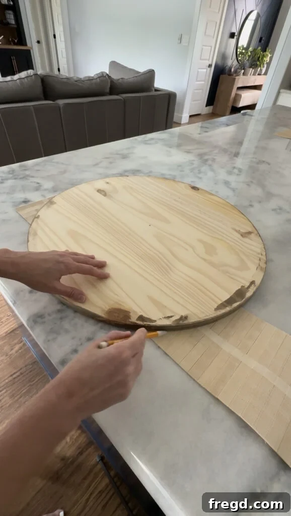 Tracing the curve of the wood circle onto the pole wrap.