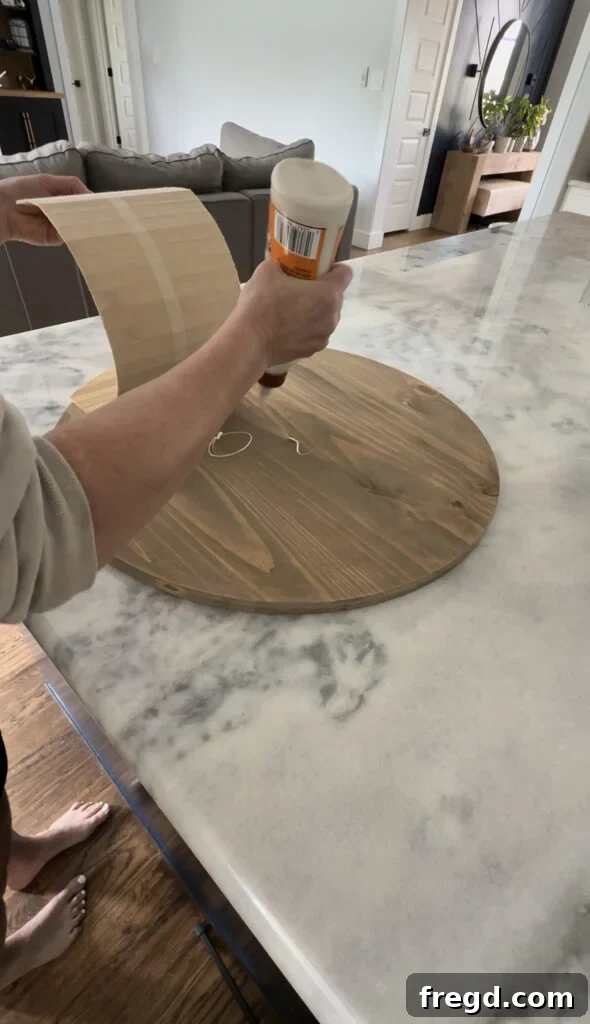 Applying wood glue to the back of the cut pole wrap.